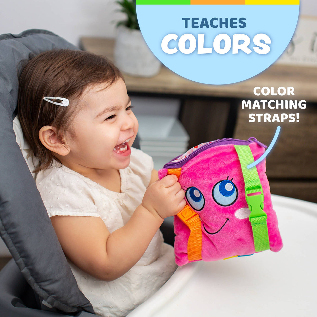 Baby happily playing with Plush Sensory Square Toy while riding in a carseat. 