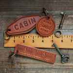 Leather Keychain Motel Style | Drive It Like You Stole It with vintage keys and ruler on a rustic wooden background.