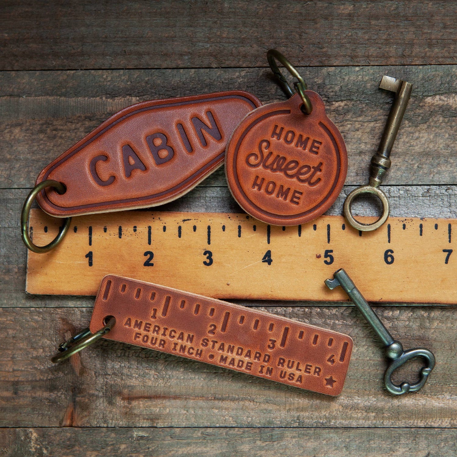 Leather Keychain Motel Style | Drive It Like You Stole It with vintage keys and ruler on a rustic wooden background.