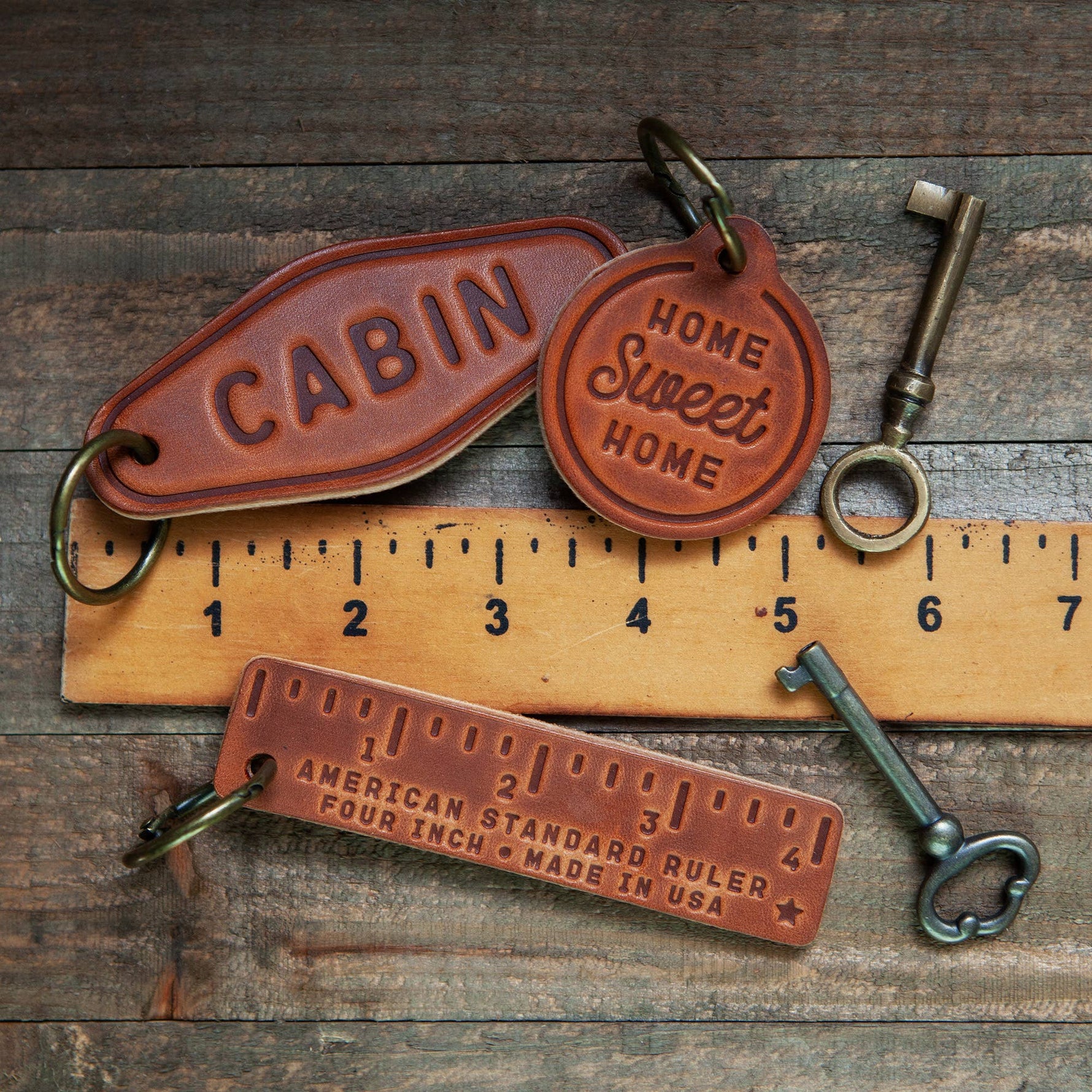 Leather Keychain Motel Style | Drive It Like You Stole It with vintage keys and ruler on a rustic wooden background.