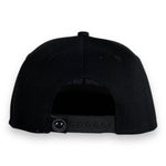 Back view of a toddler snapback hat showcasing adjustable snap closure and sleek black design.