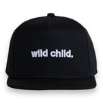 Toddler snapback hat featuring 'wild child.' embroidered in white on a black cap, perfect for energetic little ones.